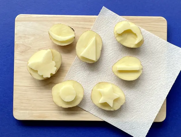 Potato printed red hearts on white paper