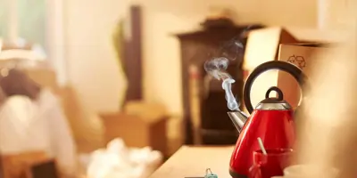 A red clean kettle boiling on the kitchen counter