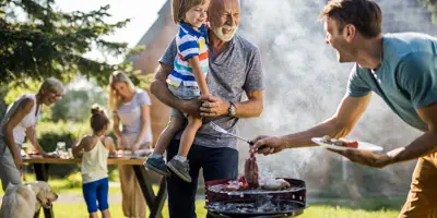 Man bereidt een barbecue voor in de achtertuin van het gezin