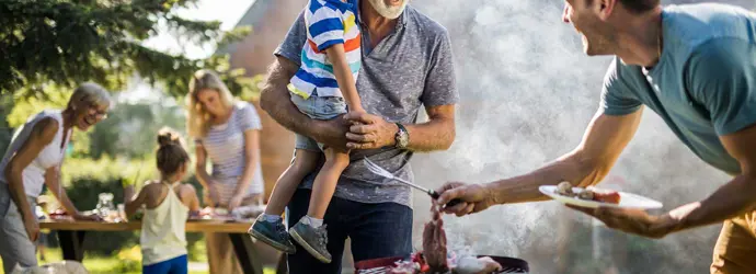 Man bereidt een barbecue voor in de achtertuin van het gezin