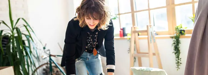 Woman unpacking a cardboard box during a house decluttering