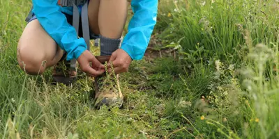 Kind strikt de veters van zijn wandelschoenen buiten