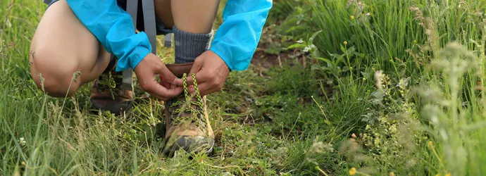 Kind strikt de veters van zijn wandelschoenen buiten