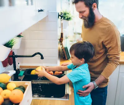 Eine Mutter hilft ihren Kindern sich die Hände zu waschen