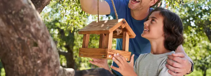 Man and child with bird feeder