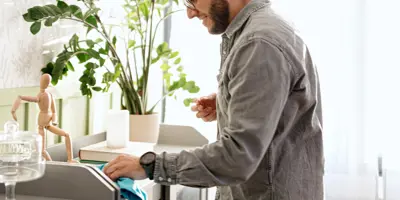 Man in grey shirt deep cleans his home.