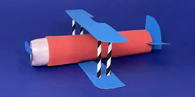 A cardboard airplane made out of a paper tube, cardboard, straws, and other recycled materials.